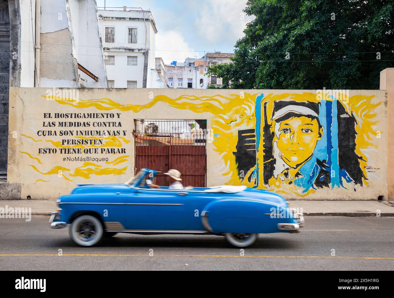 La Chevy degli anni '1950 passa il murale dell'Avana. Il testo recita: "Le molestie e le misure contro Cuba sono disumane e persistono, questo deve finire. Basta blocchi Foto Stock