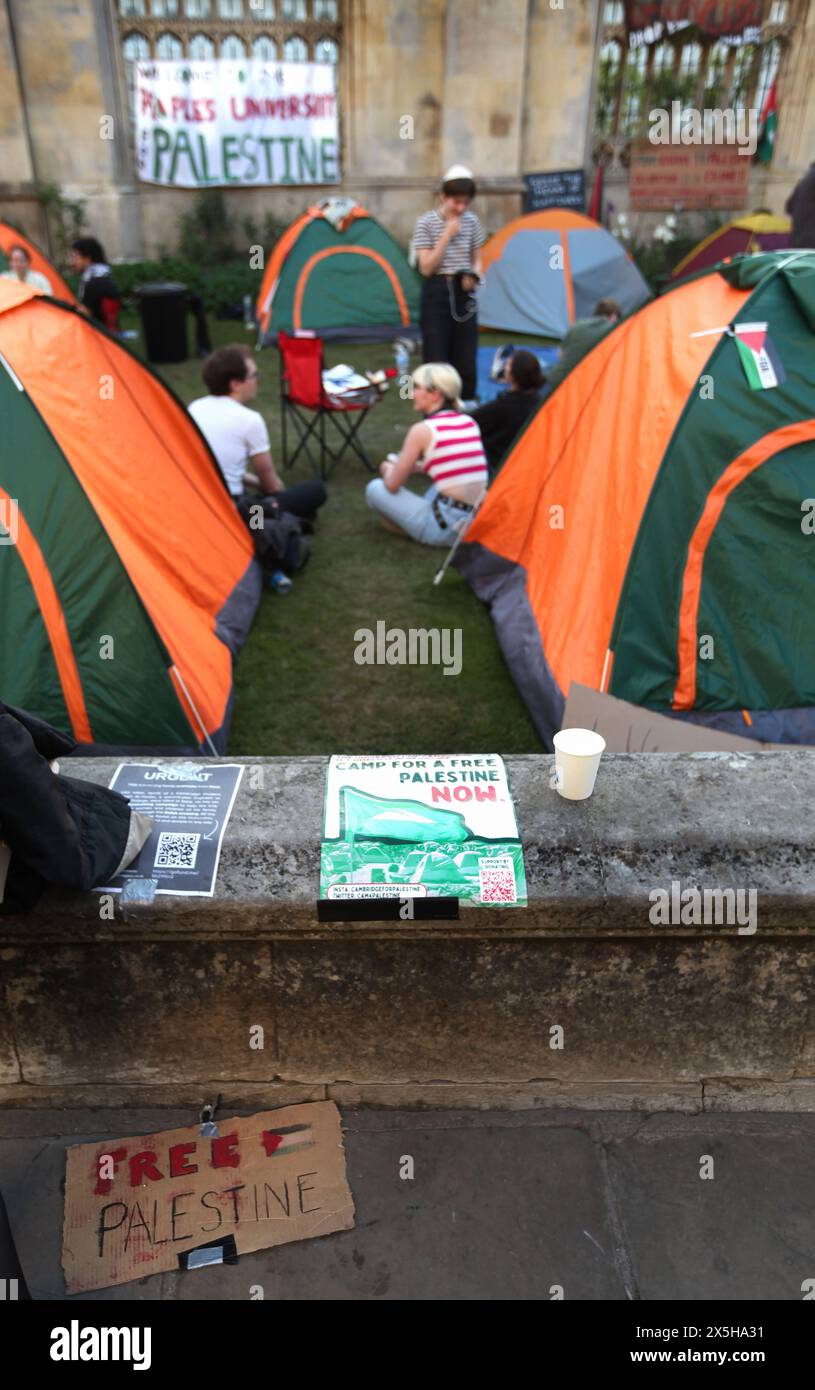 I manifestanti siedono nel campo mentre un cartello giace sul marciapiede esterno che dice "Palestina libera” durante la manifestazione. Un campo di protesta a sostegno della Palestina è stato istituito e continua a svilupparsi il giorno 3, fuori dal King's College di Cambridge. Coloro che occupano il campo chiedono all'università di condurre un audit etico, di porre fine a tutti gli investimenti, fornisce collaborazioni di ricerca con qualsiasi organizzazione che sia complice dell'occupazione israeliana della Palestina e del genocidio a Gaza e diventa un'Università di Santuario per i rifugiati palestinesi e sostiene studenti e accademici palestinesi. Manifestante Foto Stock