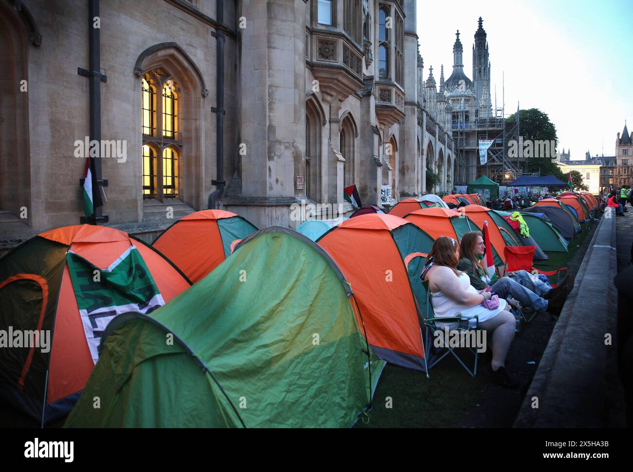 Mentre la notte si avvicina, due manifestanti al campo si siedono all'interno del muro di confine e si ritrovano. Un campo di protesta a sostegno della Palestina è stato istituito e continua a svilupparsi il giorno 3, fuori dal King's College di Cambridge. Coloro che occupano il campo chiedono all'università di condurre un audit etico, di porre fine a tutti gli investimenti, fornisce collaborazioni di ricerca con qualsiasi organizzazione che sia complice dell'occupazione israeliana della Palestina e del genocidio a Gaza e diventa un'Università di Santuario per i rifugiati palestinesi e sostiene studenti e accademici palestinesi. I manifestanti sono determinati a rimanere io Foto Stock