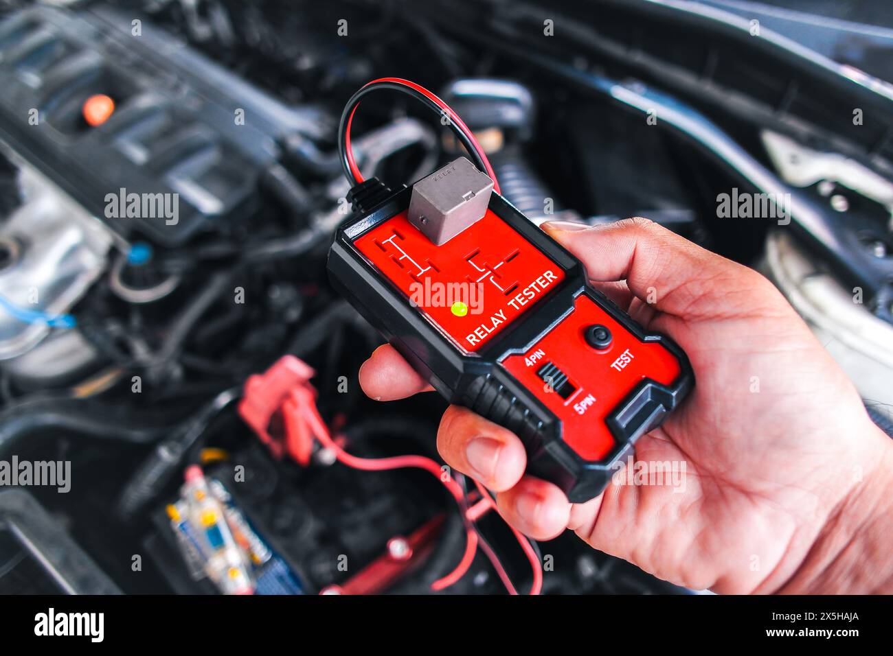 Test relè auto con un tester relè , tester relè in mano meccanico per test di sistema , concetto di manutenzione e riparazione auto Foto Stock