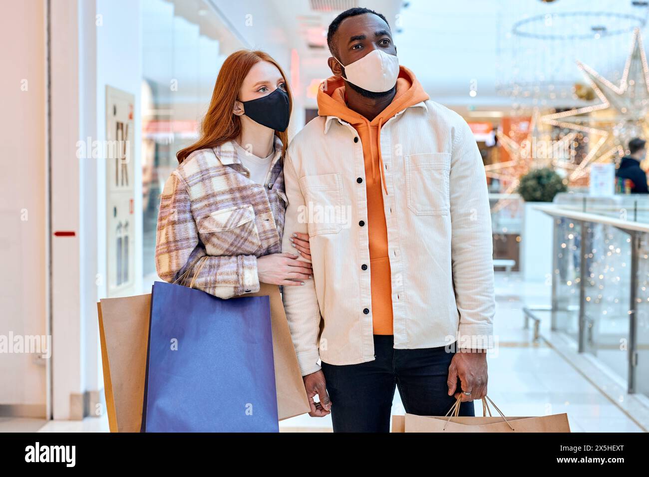 una giovane coppia attraente ha paura degli shaops affollati, della gente mentre fa shopping al centro commerciale, fera. foto ravvicinata. Foto Stock