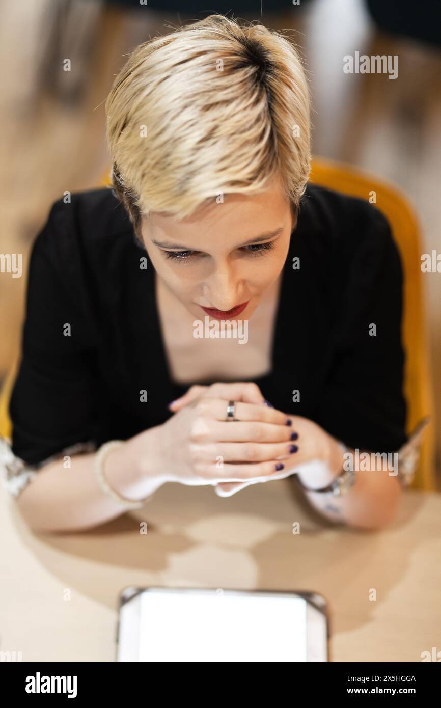 Una donna d'affari specializzata utilizza un tablet digitale durante una riunione d'affari in un ambiente elegante, rappresentando tecnologia e autobus moderni Foto Stock