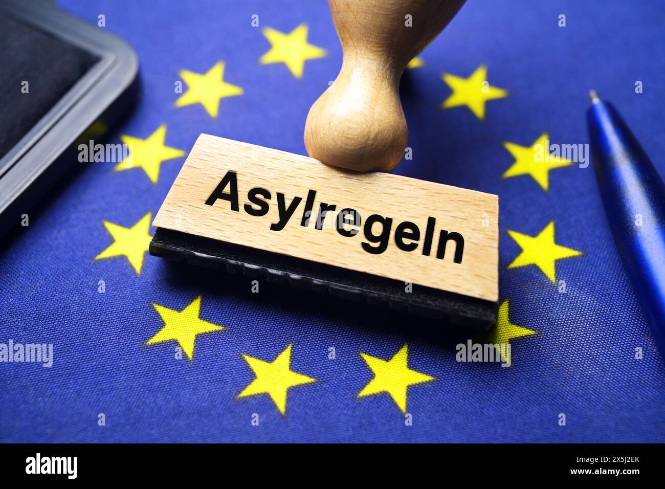 FOTOMONTAGE, Stempel mit Aufschrift Asylregeln auf EU-Fahne, EU-Asylpakt Foto Stock