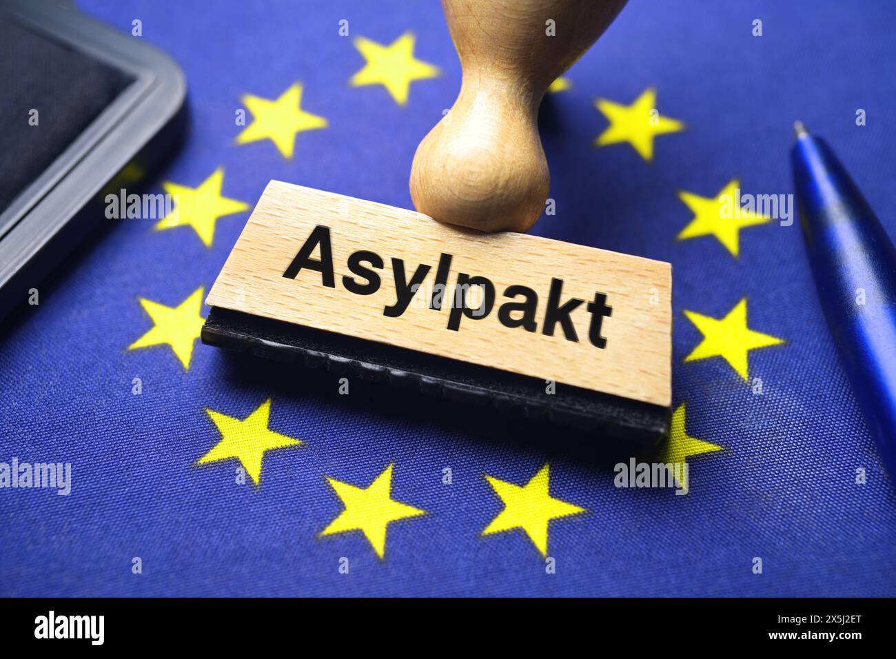 FOTOMONTAGE, Stempel mit Aufschrift Asylpakt auf EU-Fahne, EU-Asylpakt Foto Stock