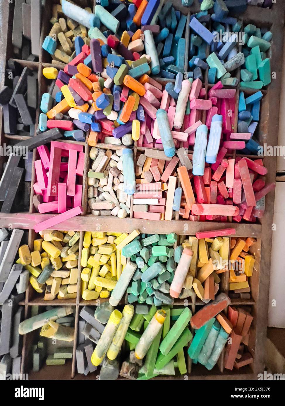 Vivace gamma di pastelli usati in un organizer in legno Foto Stock