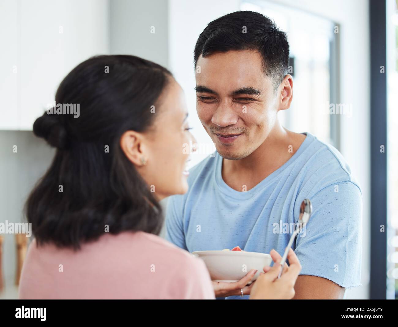 Coppia, amore e mangiare con la colazione in casa con sorriso o cura con il legame in cucina con il cibo. Mattina, persone e rapporto sano con Foto Stock