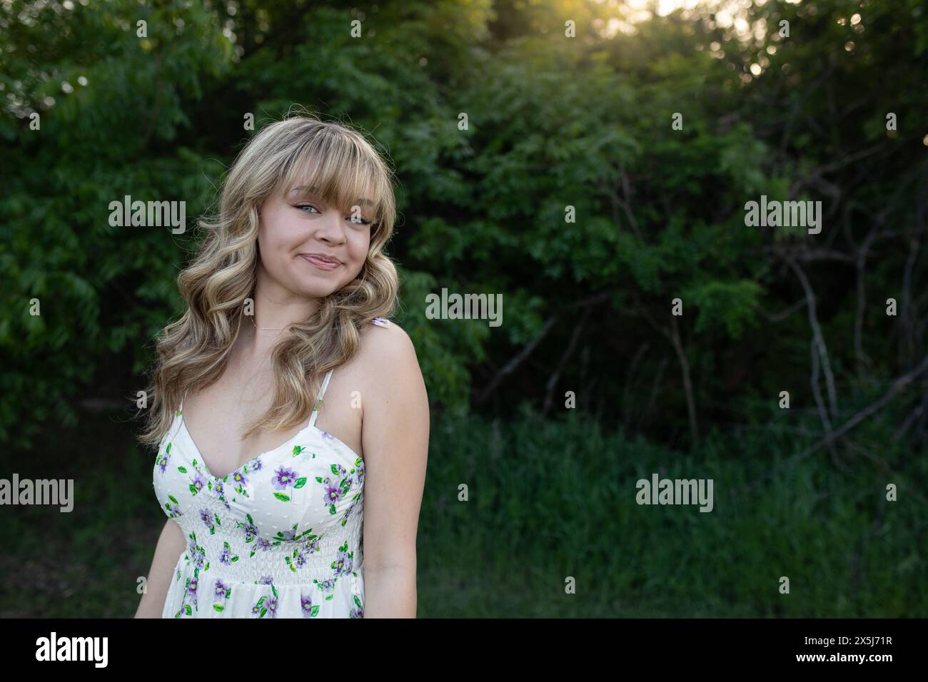 giovane donna sul campo, vestito bianco radioso Foto Stock