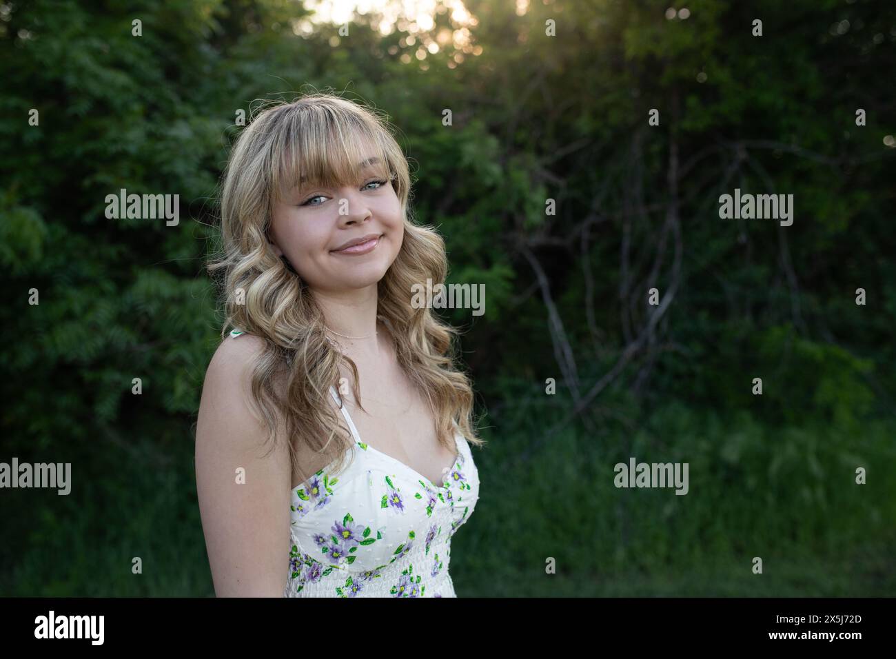 giovane donna sul campo, vestito bianco radioso Foto Stock