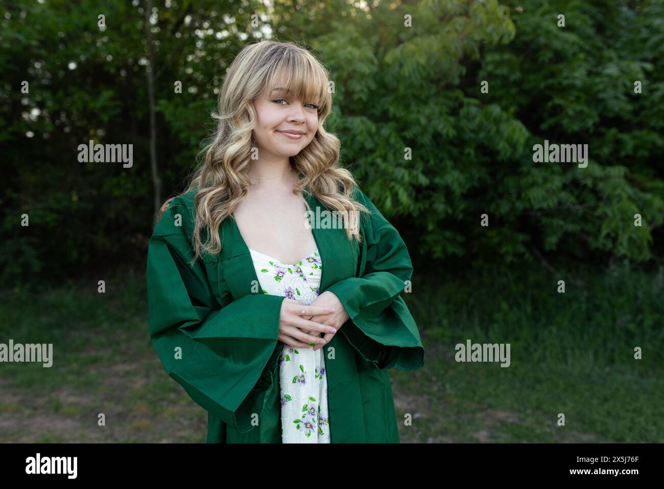 Gioiosa giovane donna caucasica celebra la laurea sul campo Foto Stock