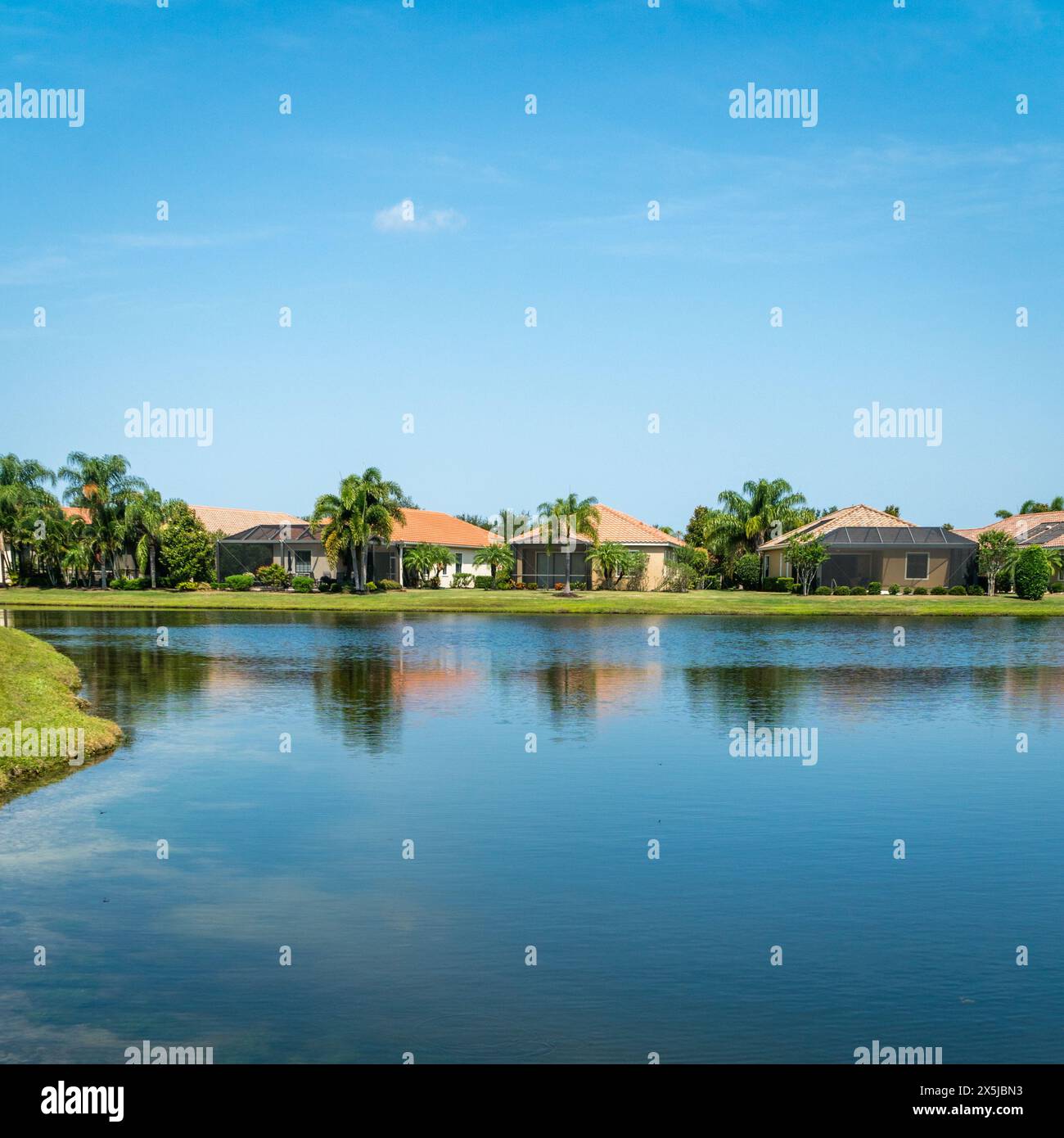 Lakewood Ranch, Florida, Stati Uniti - 15 settembre 2022: Case sul lago nella comunità recintata della classe media superiore con palme e cielo blu. Foto Stock
