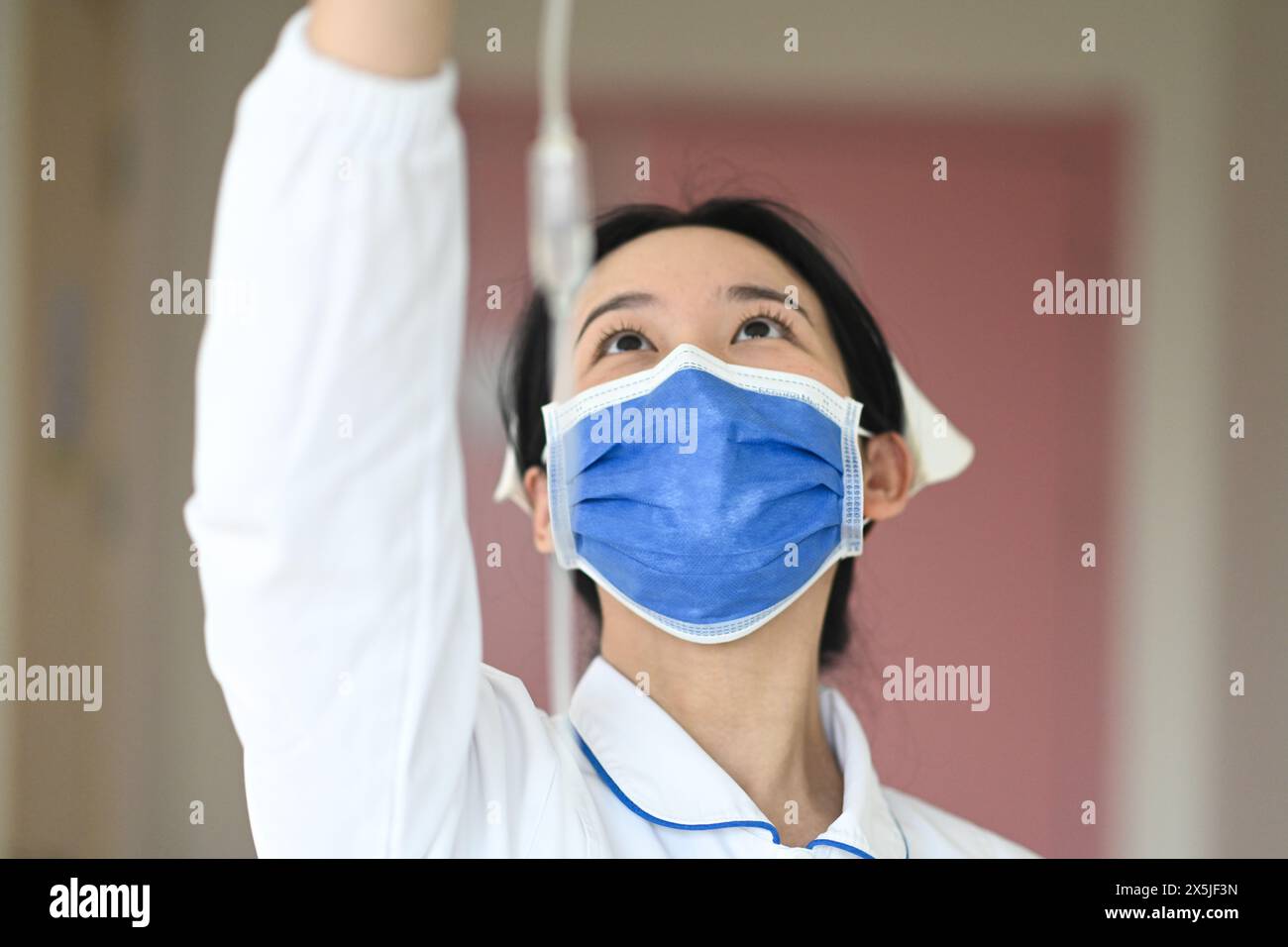 NANCHANG, CINA - 10 MAGGIO 2024 - Un'infermiera ispeziona l'infusione di un bambino ricoverato in ospedale presso il dipartimento di otorinolaringoiatria dell'Hospita dei bambini di Jiangxi Foto Stock