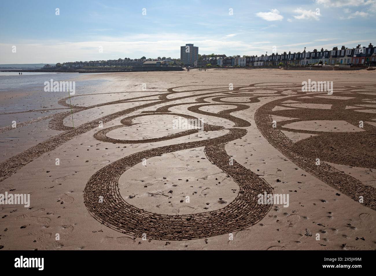 Portobello, Edimburgo, Scozia, Regno Unito. 10 maggio 2024. Neil Walker di Edimburgo ama creare disegni di Land art sulla sabbia bagnata. Quando gli è stato chiesto il titolo di questo lavoro, ha risposto pratica 69. La Land art, conosciuta anche come Earth art, Environmental art e Earthworks, è un movimento artistico che emerse negli anni '1960 e '1970, in gran parte associato alla Gran Bretagna e agli Stati Uniti, ma che include anche esempi provenienti da molti paesi. Temperatura 19 gradi centigradi con luce solare nebulizzata. Credito: Arch White/alamy notizie dal vivo. Foto Stock