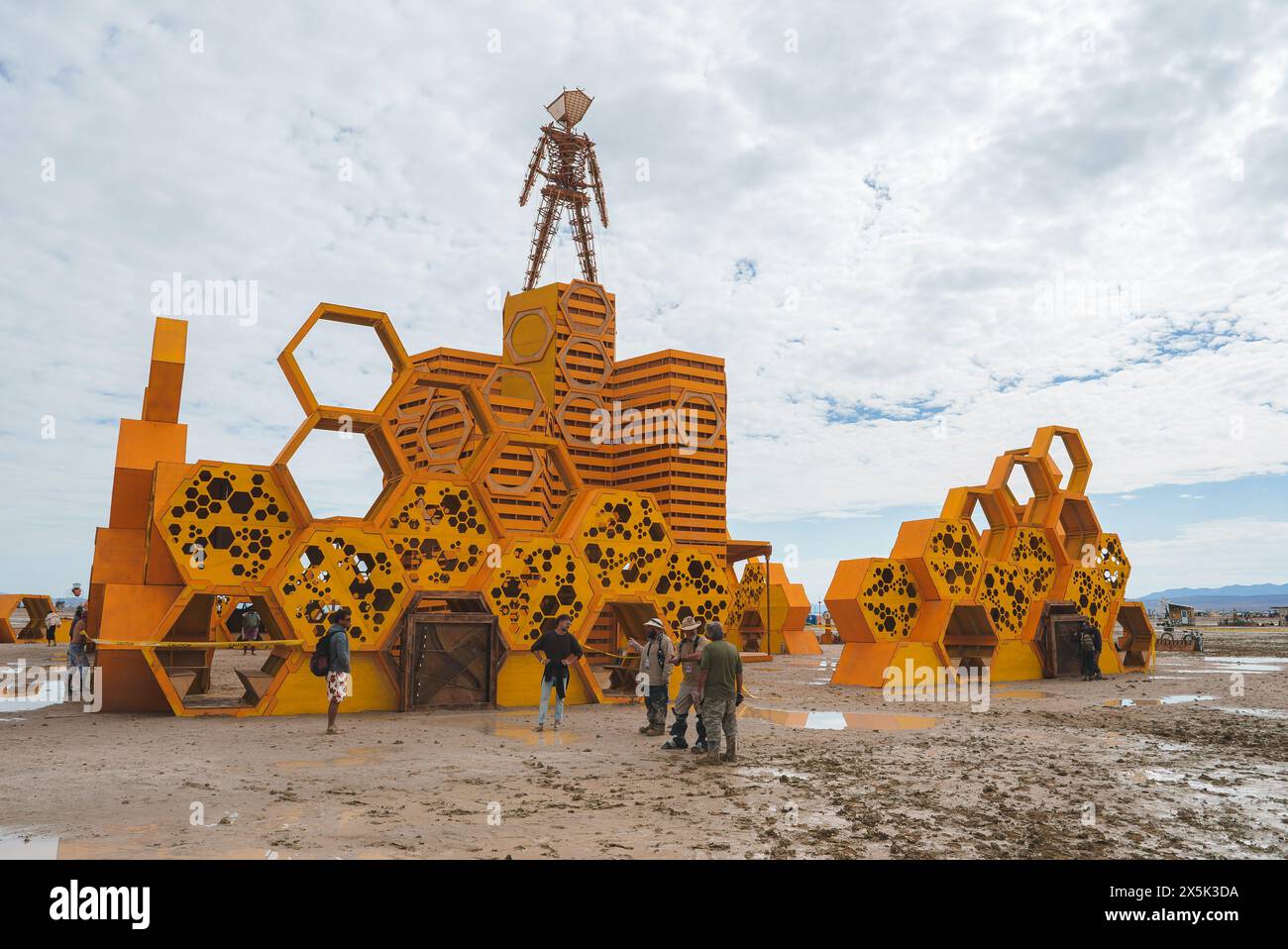 Impressionante installazione di arte geometrica in ambientazione desertica, colori tenui, Tower Figure, persone che esplorano Foto Stock