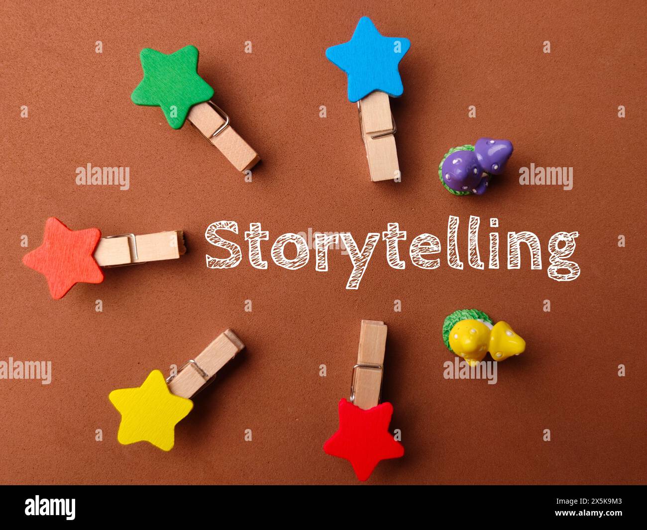 Vista dall'alto clip in legno con testo Storytelling su sfondo marrone. Foto Stock