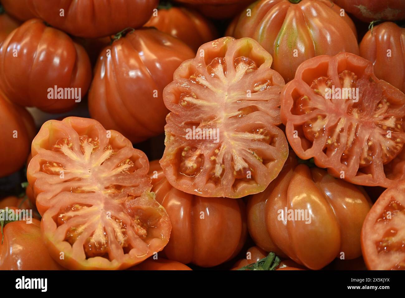 Pomodori rossi spagnoli alcuni tagliati a metà altri interi Foto Stock