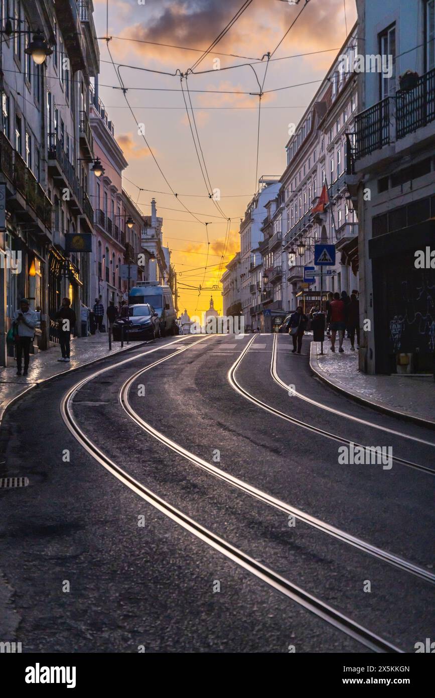 Portogallo, Lisbona. I tracciati delle auto di strada riflettono il cielo colorato del tramonto. Foto Stock