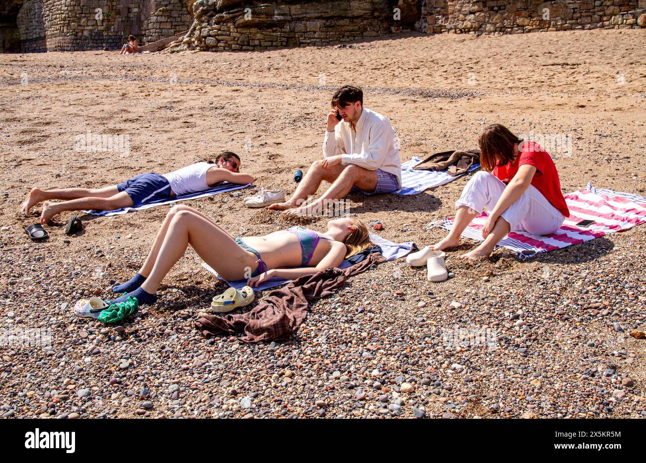St Andrews, Fife, Scozia, Regno Unito. 10 maggio 2024. Meteo nel Regno Unito: St Andrews sperimenta una mini onda di calore a molla con temperature che raggiungono i 25°C.. La gente del posto e i turisti trascorrono la giornata a Castle Beach godendosi il caldo sole di maggio. Crediti: Dundee Photographics/Alamy Live News Foto Stock
