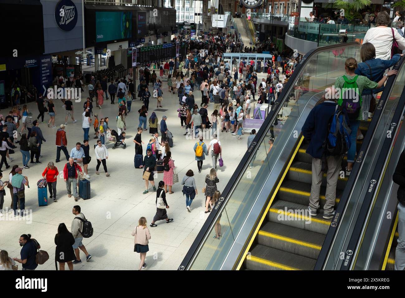 Le persone con le valigie si riuniscono alla stazione di Waterloo a Londra all'inizio del fine settimana festivo. Foto Stock