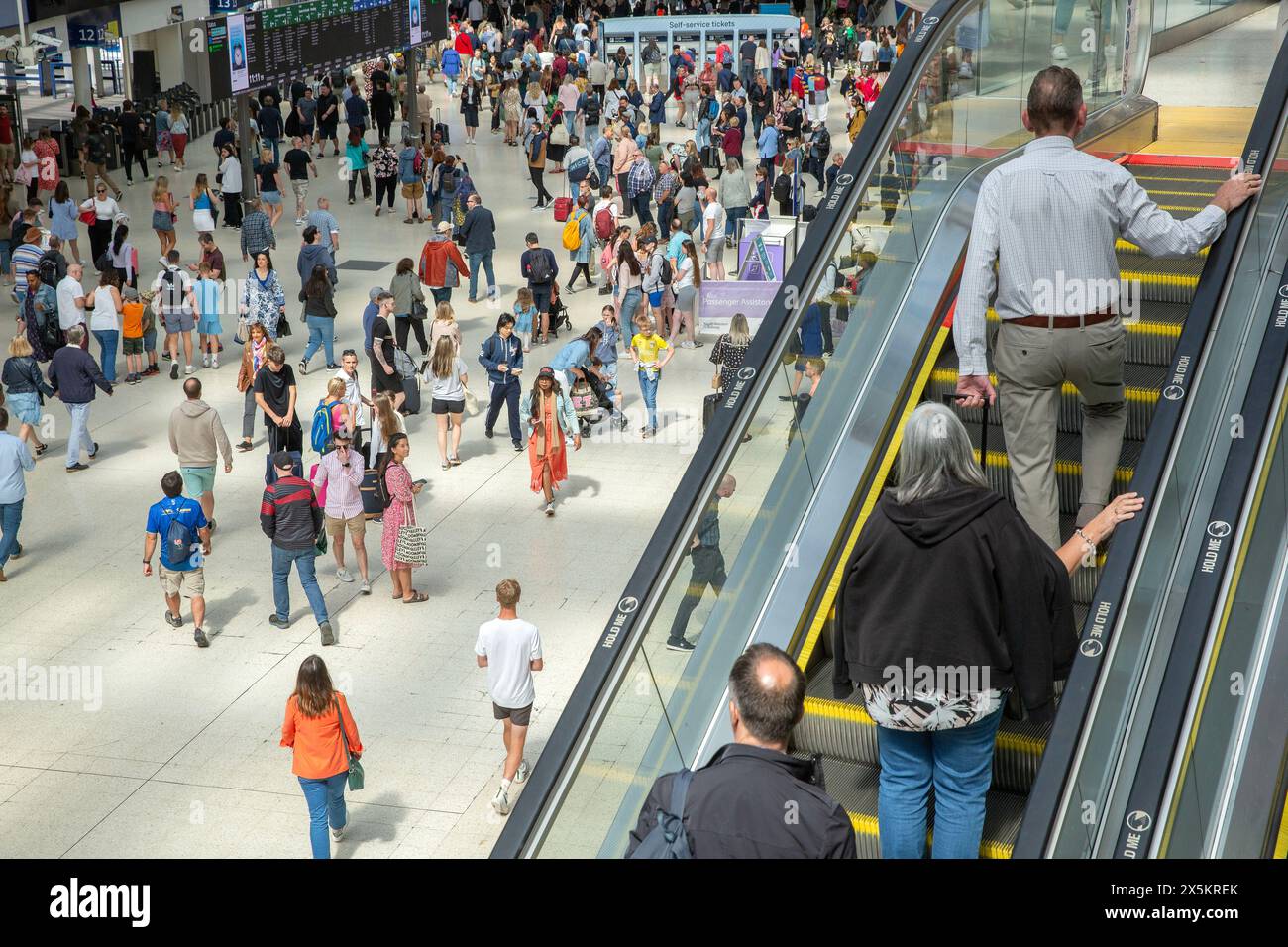 Le persone con le valigie si riuniscono alla stazione di Waterloo a Londra all'inizio del fine settimana festivo. Foto Stock