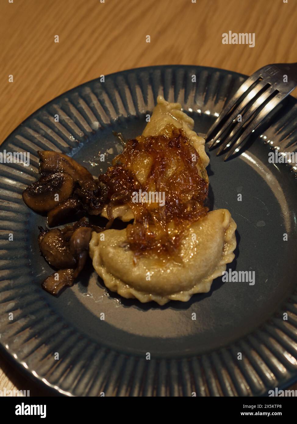 Primo piano verticale di un piatto con gnocchi e cipolla caramellata. Foto Stock