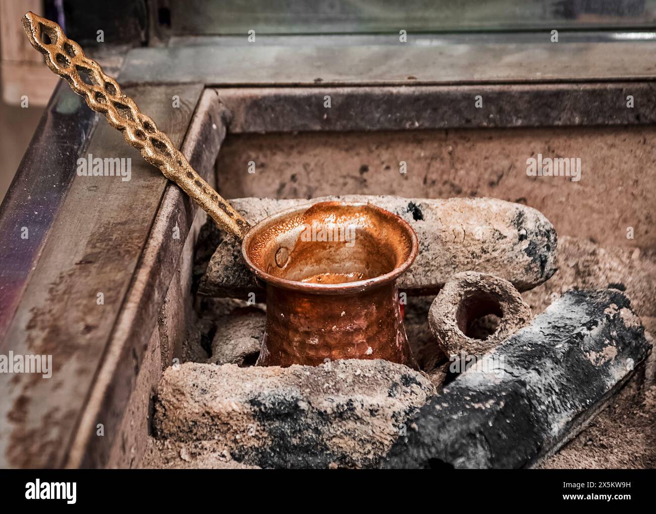 Tipico contenitore in bronzo posto su carboni caldi per la preparazione del caffè turco Foto Stock