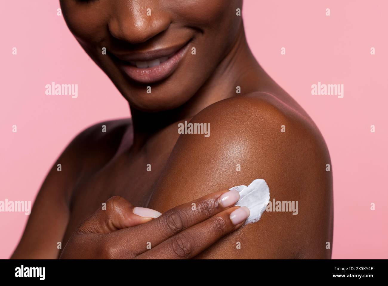 Giovane donna l'applicazione di crema sulla spalla Foto Stock