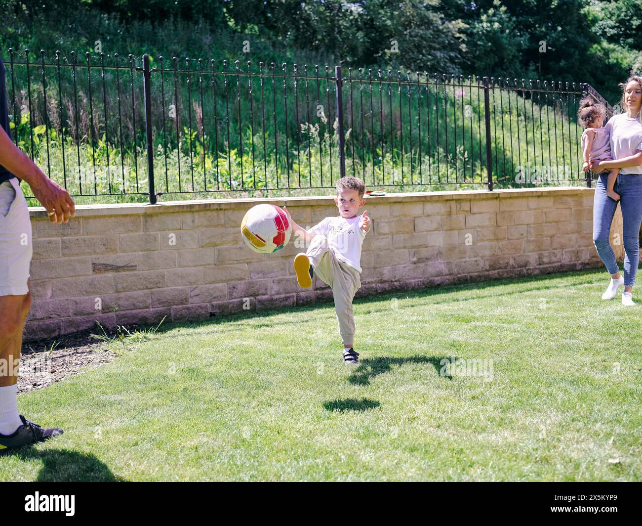 Padre con figlio che gioca a calcio nel cortile posteriore Foto Stock