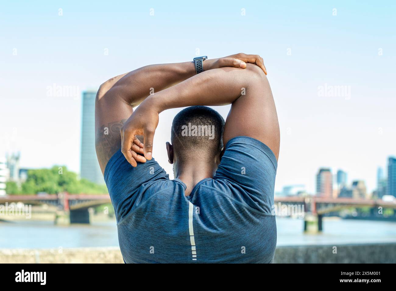 Vista posteriore dell'uomo medio adulto che si allunga Foto Stock