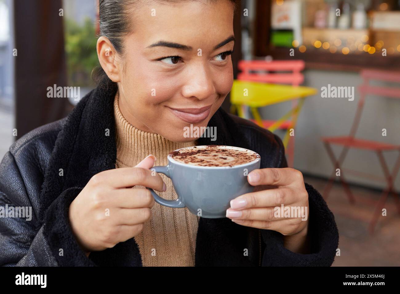 Donna di mezza età che beve un caffè nel caffè marciapiede Foto Stock