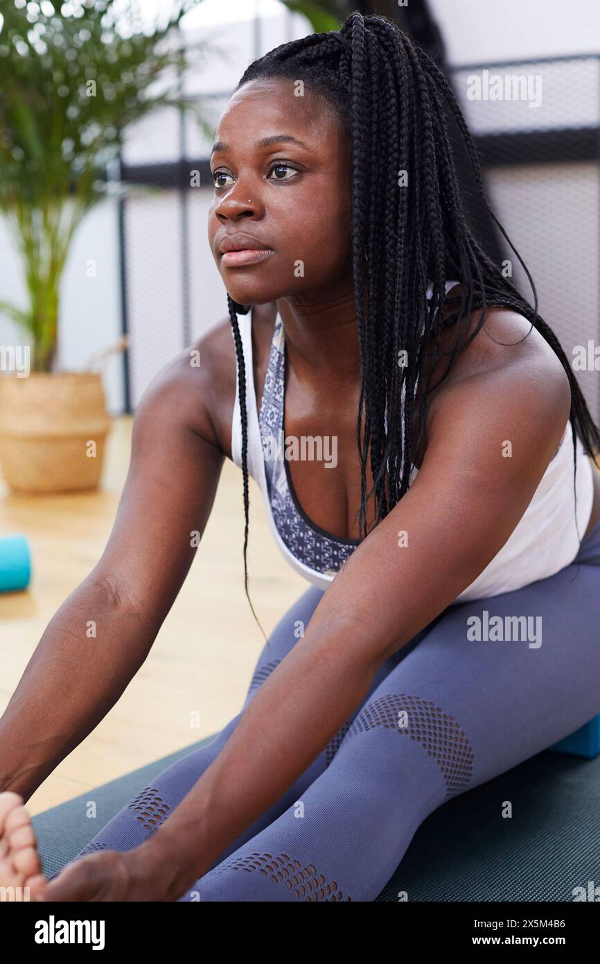 La donna si allunga a materassino yoga Foto Stock