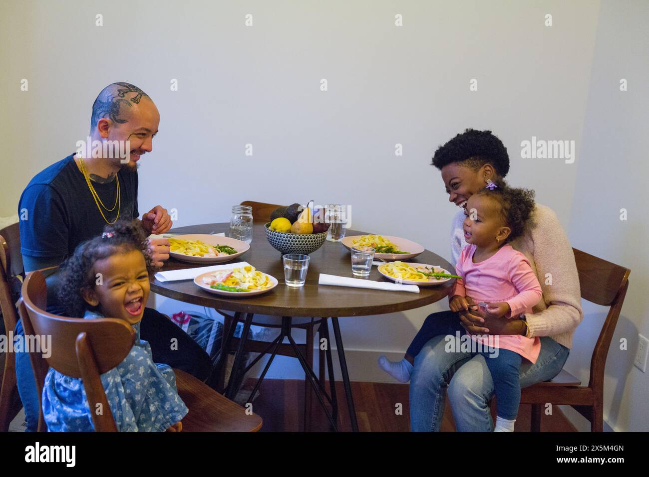 Famiglia con figlie che pranzano a tavola Foto Stock