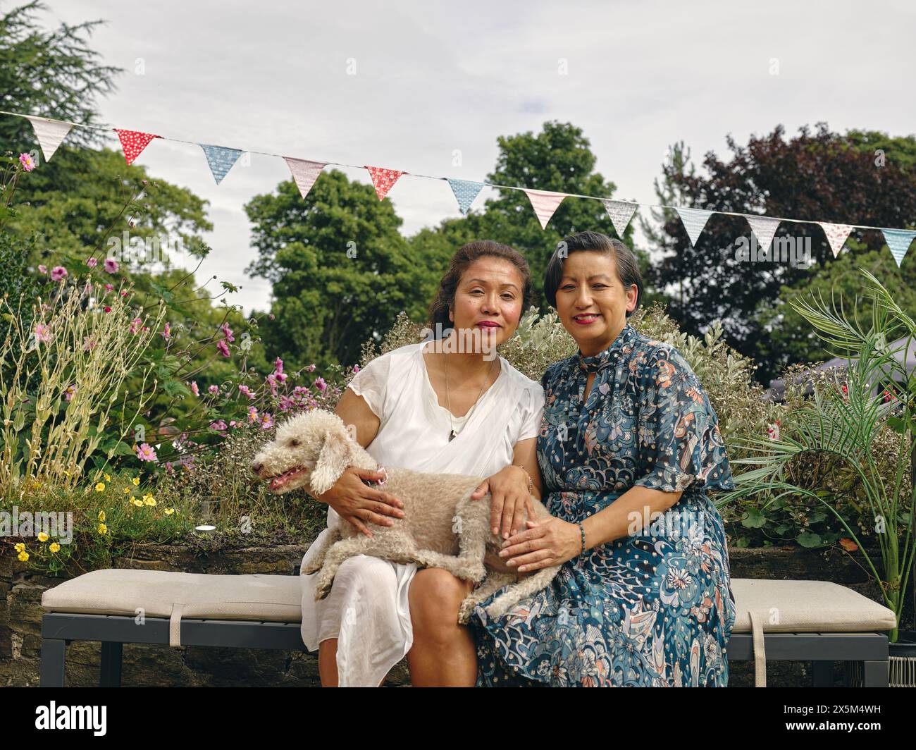 Ritratto di sorelle sorridenti che tengono il cane Foto Stock