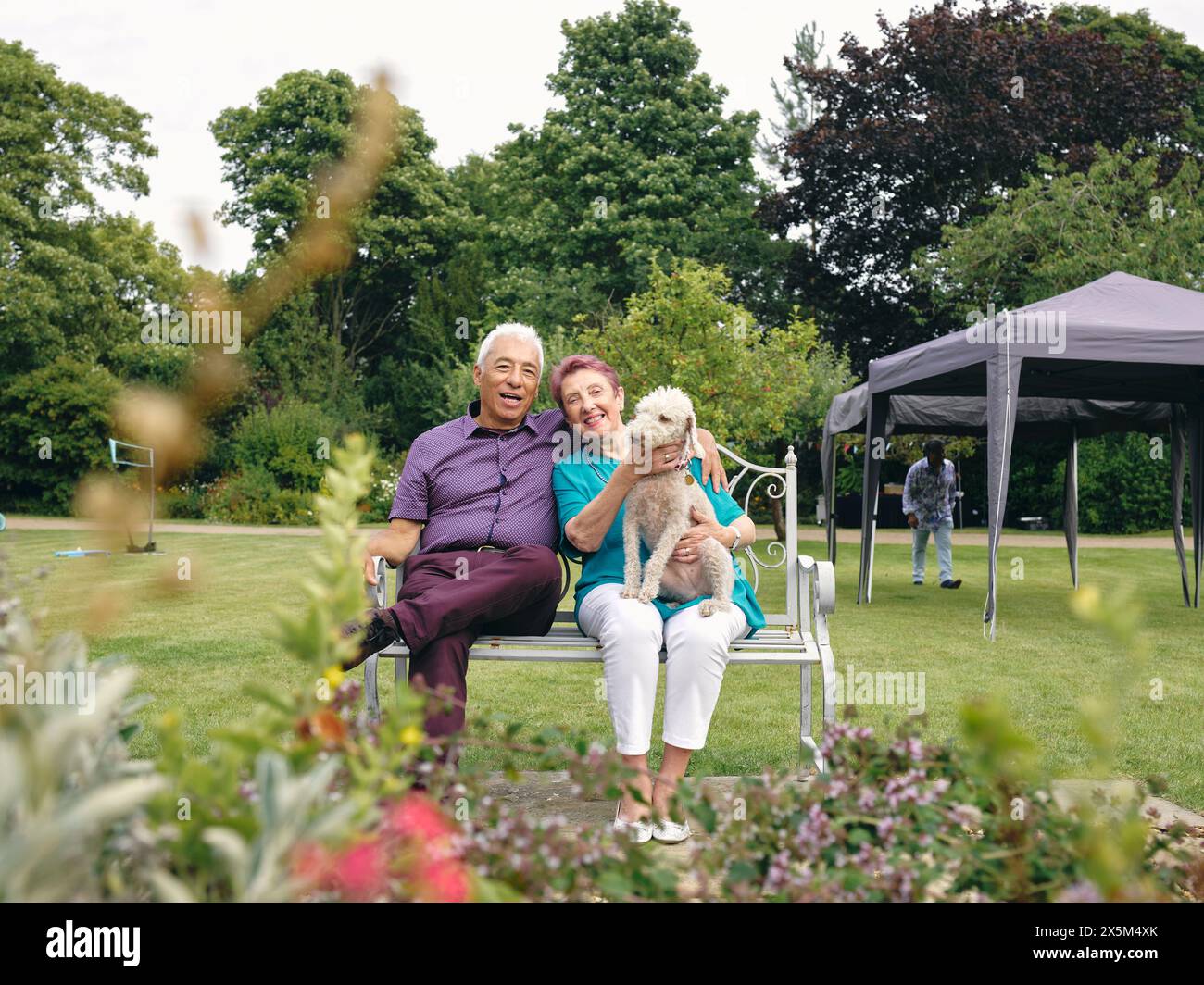 Ritratto di una coppia anziana con un cane nel cortile Foto Stock