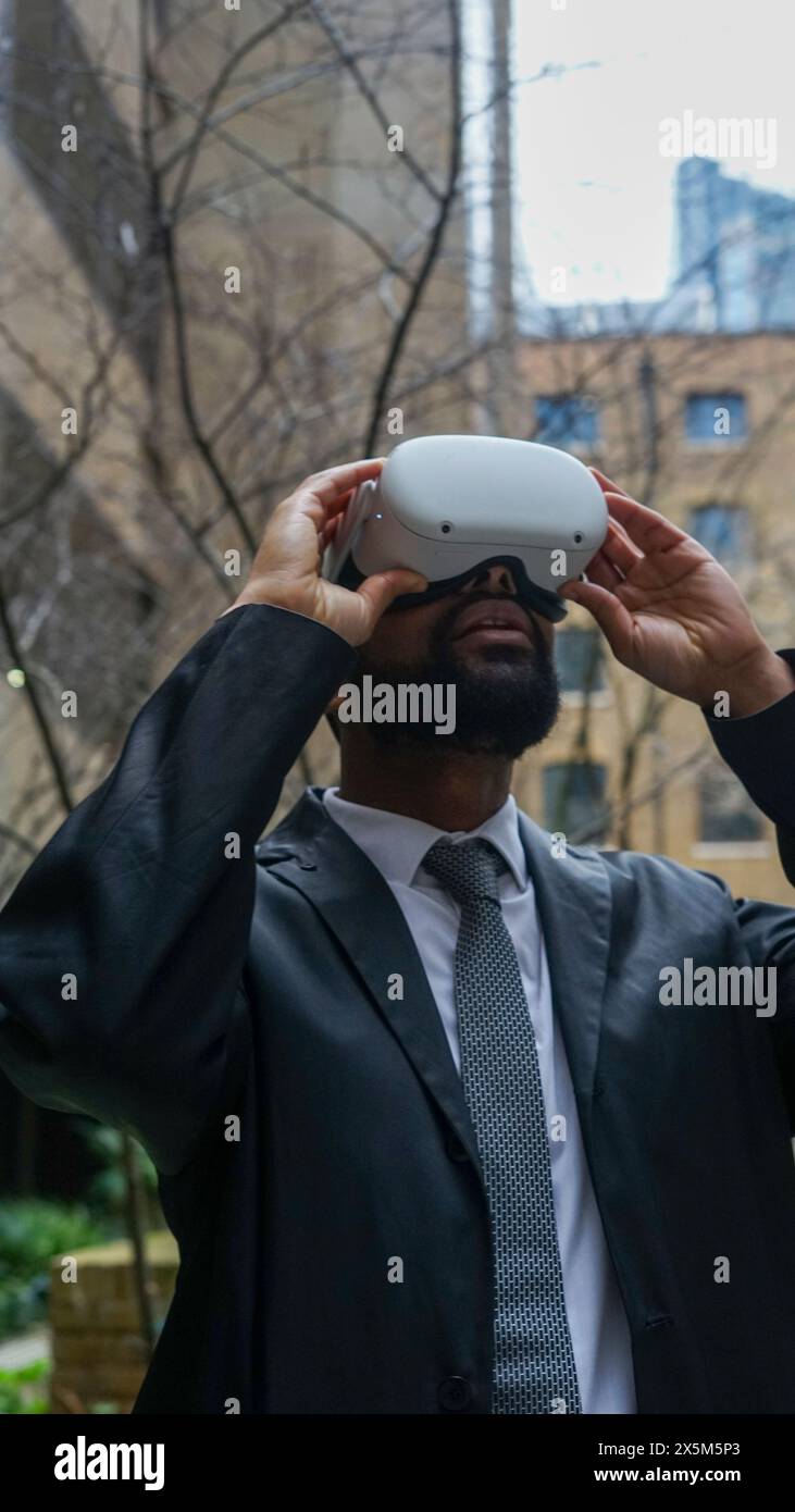Uomo d'affari che usa il visore VR Foto Stock