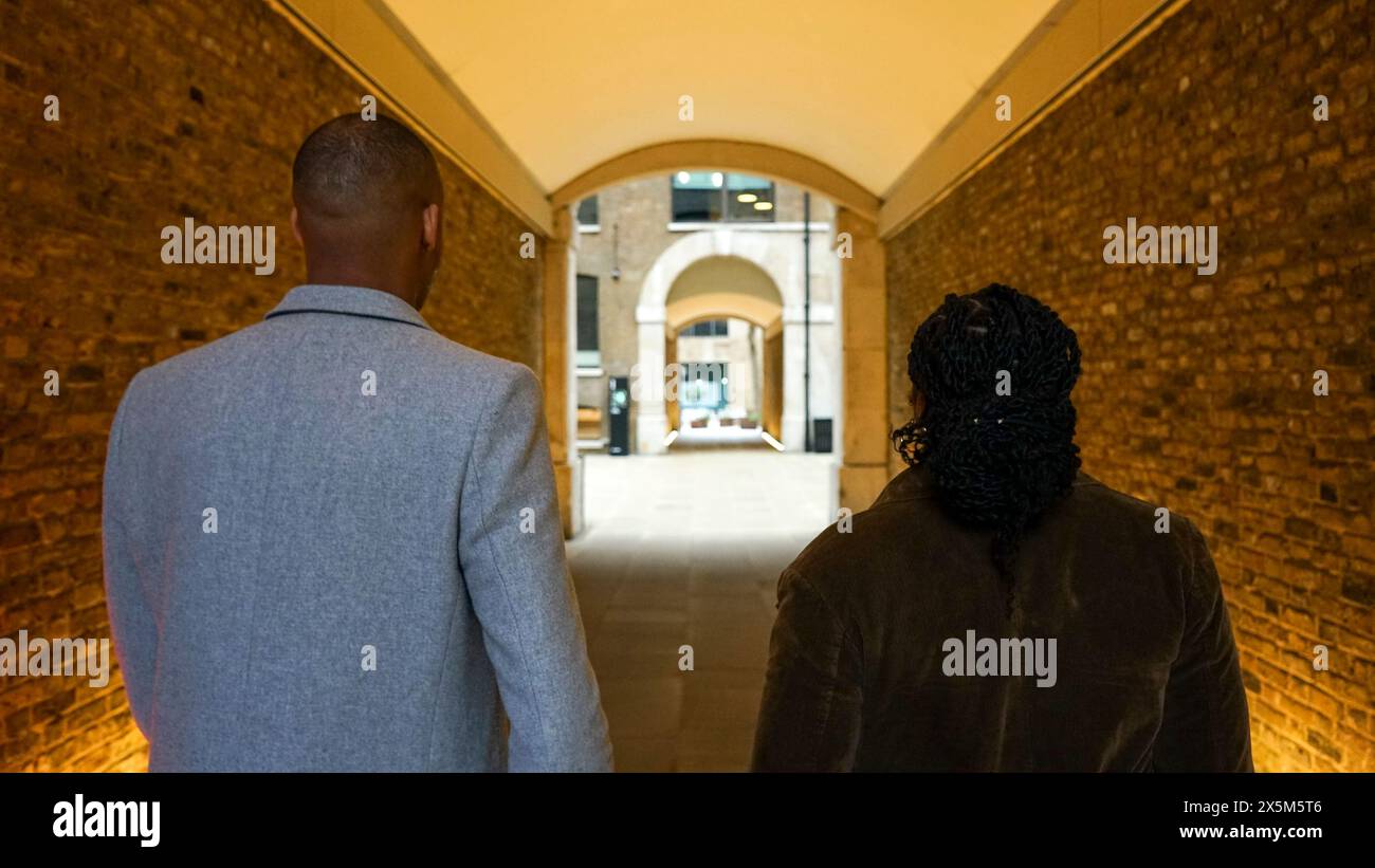Uomo d'affari e donna che camminano nel tunnel Foto Stock