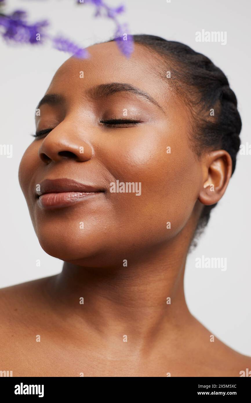 Ritratto in studio di una donna senza camicia sorridente con gli occhi chiusi Foto Stock