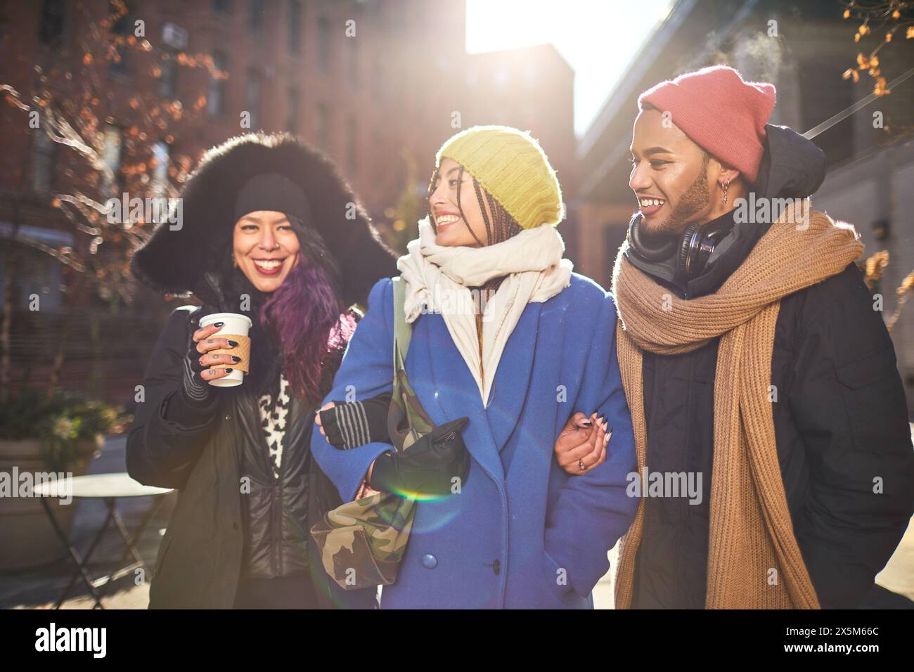 USA, New York City, amici sorridenti per strada nella giornata fredda Foto Stock