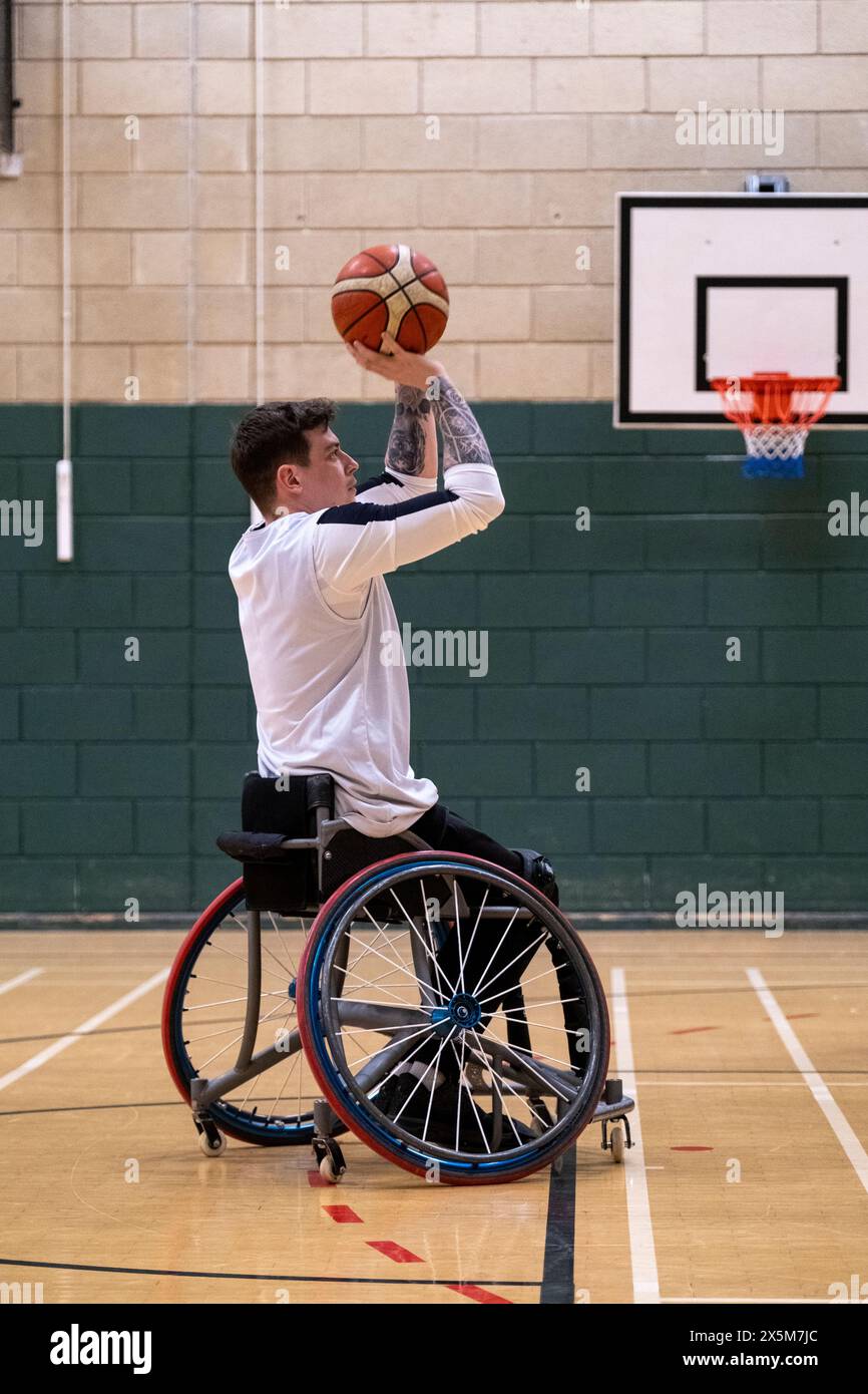 Giocatore di basket maschile nella palla da tiro in sedia a rotelle Foto Stock