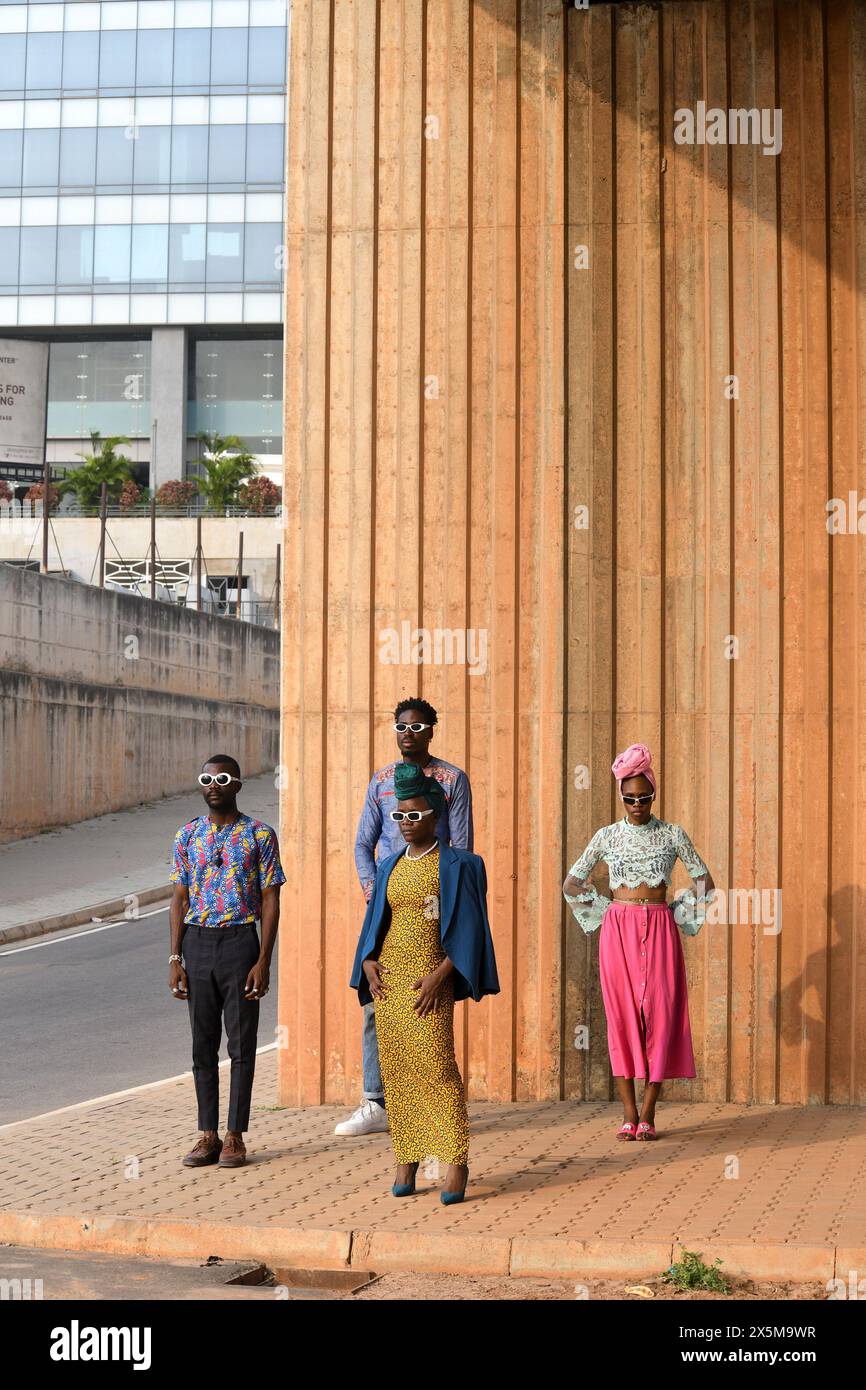 Foto alla moda di quattro persone in piedi in strada urbana Foto Stock