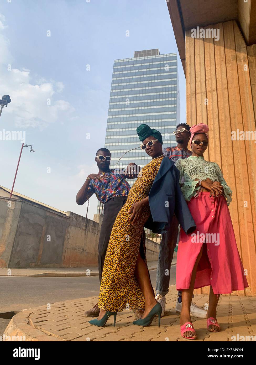 Foto alla moda di quattro persone in piedi in strada urbana Foto Stock