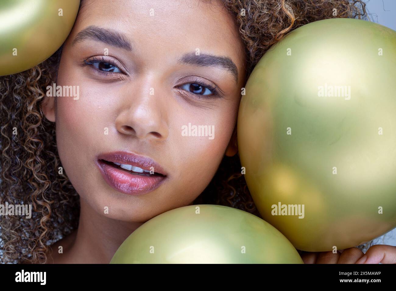 Ritratto in studio di donna con palloncini d'oro Foto Stock