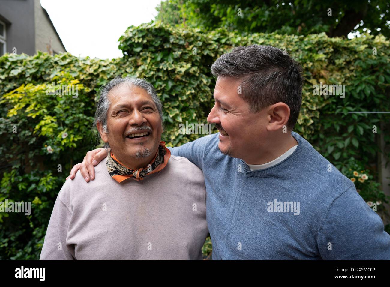 Sorridente anziano con figlio adulto all'aperto Foto Stock
