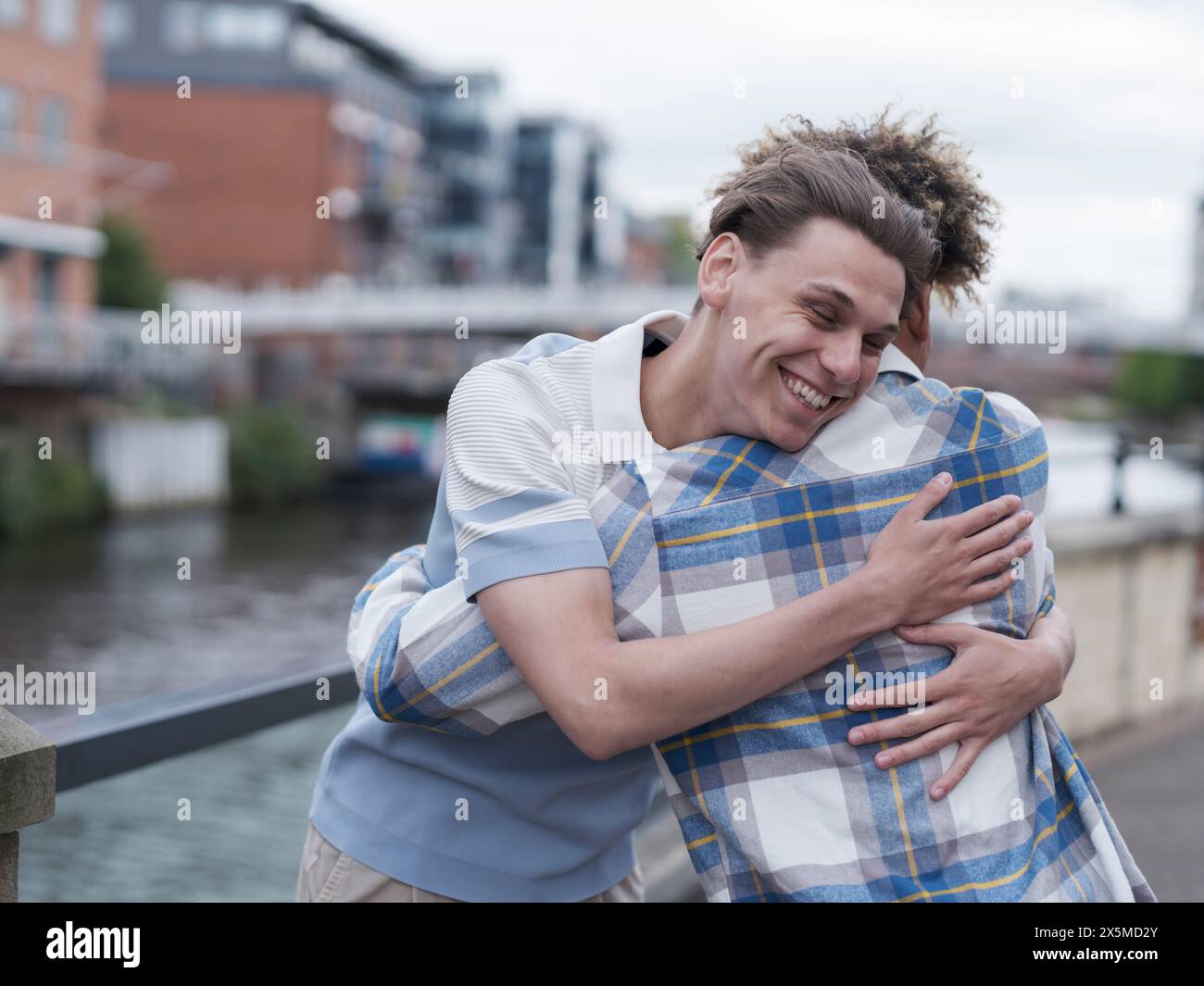 Giovani uomini che si abbracciano Foto Stock