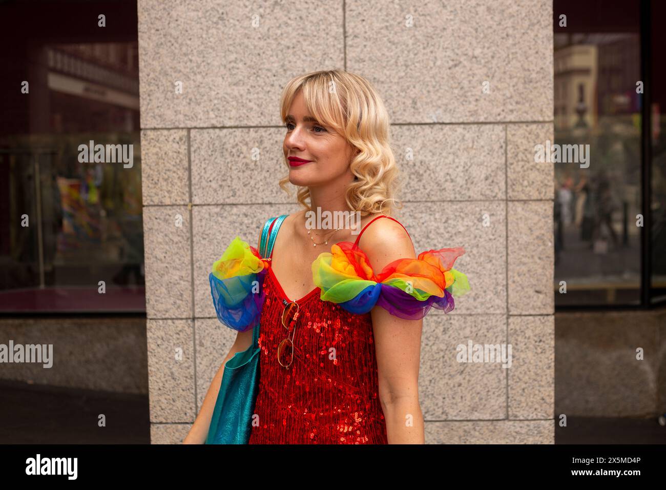 Donna adulta che indossa decorazioni a tema bandiera arcobaleno Foto Stock