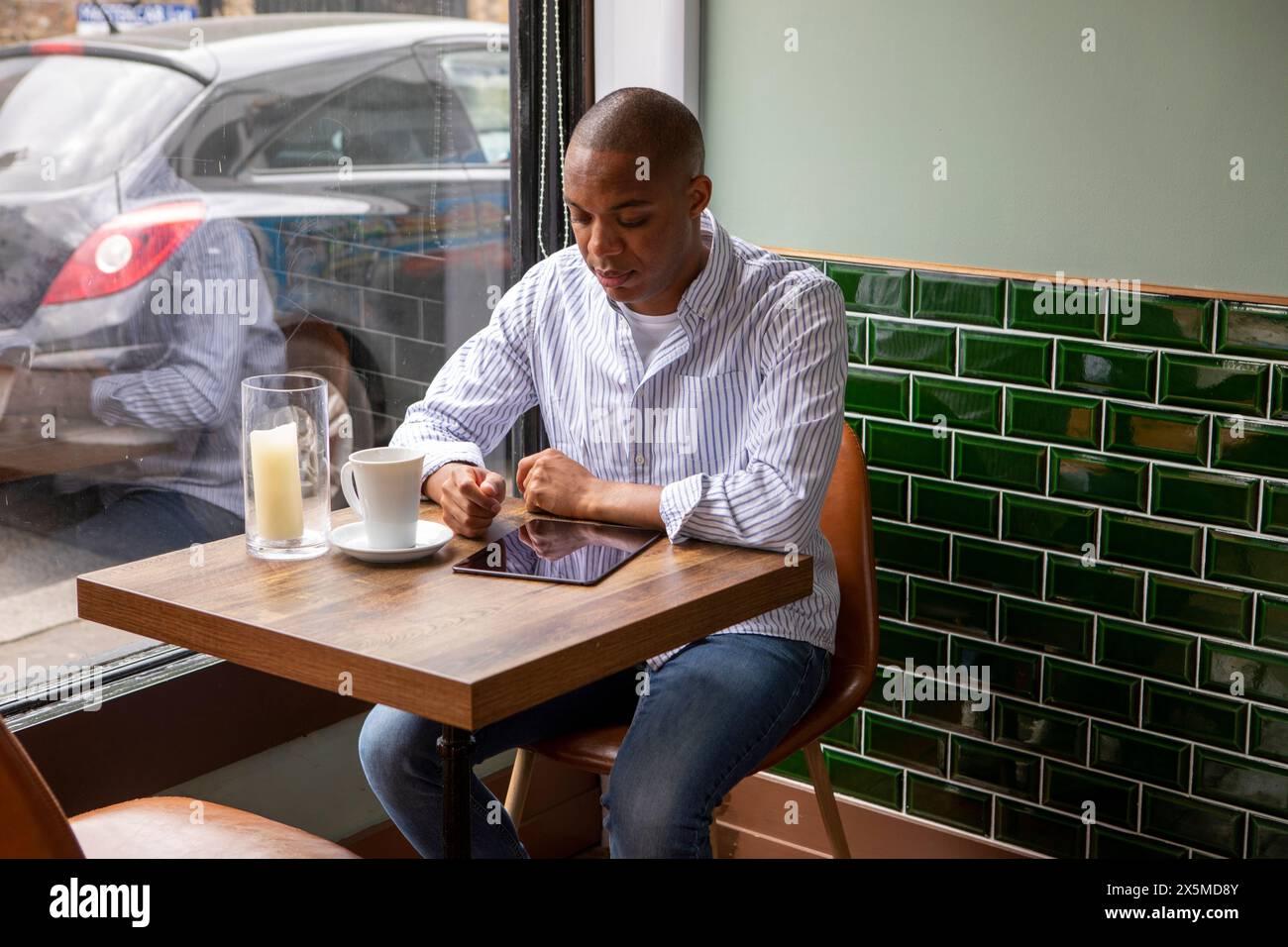 Regno Unito, Londra, uomo che usa un tablet digitale al tavolo del caffè Foto Stock