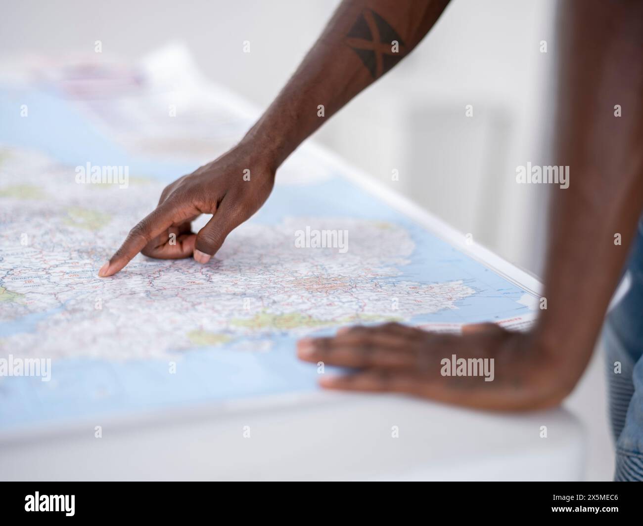 Primo piano delle mani che puntano verso la mappa sul tavolo Foto Stock Primo piano delle mani che puntano verso la mappa sul tavolo Foto Stock