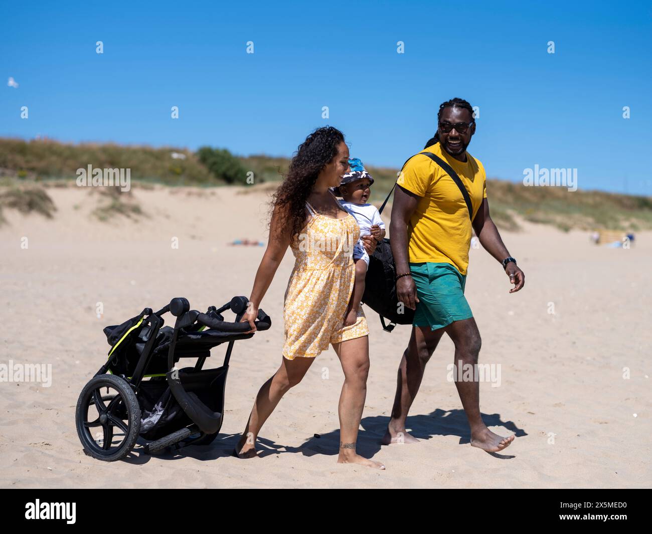 Famiglia con bambino (12-17 mesi) che va in spiaggia Foto Stock