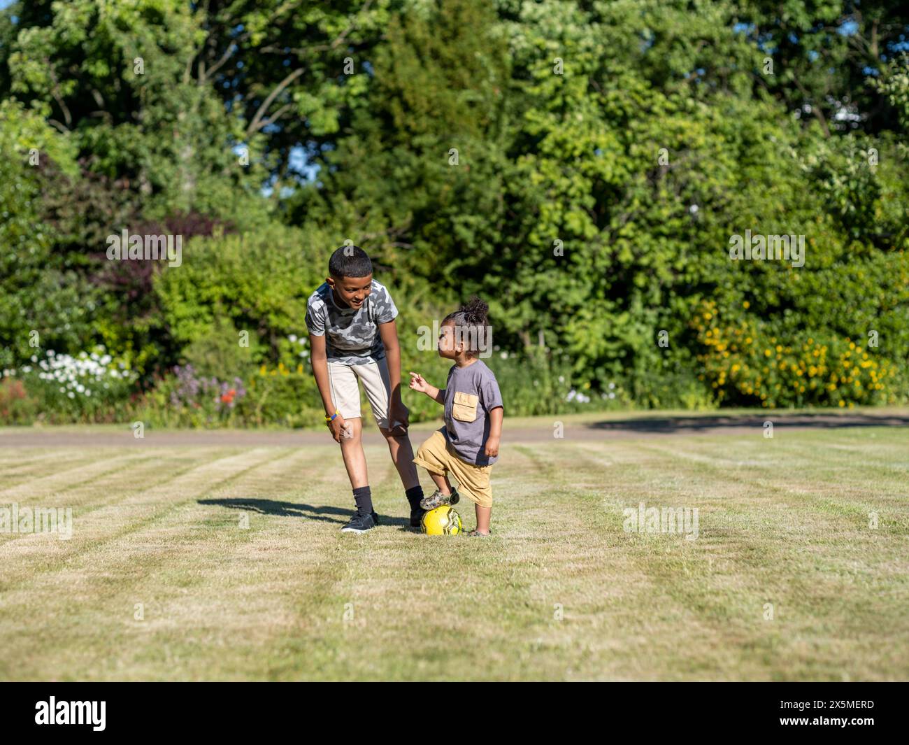 Fratelli (2-3, 10-11) che giocano a calcio Foto Stock