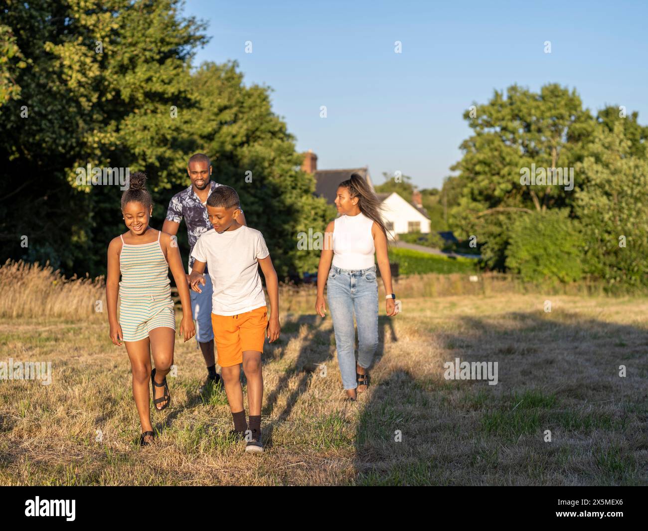 Famiglia con bambini (8-9, 10-11) che camminano in campagna Foto Stock