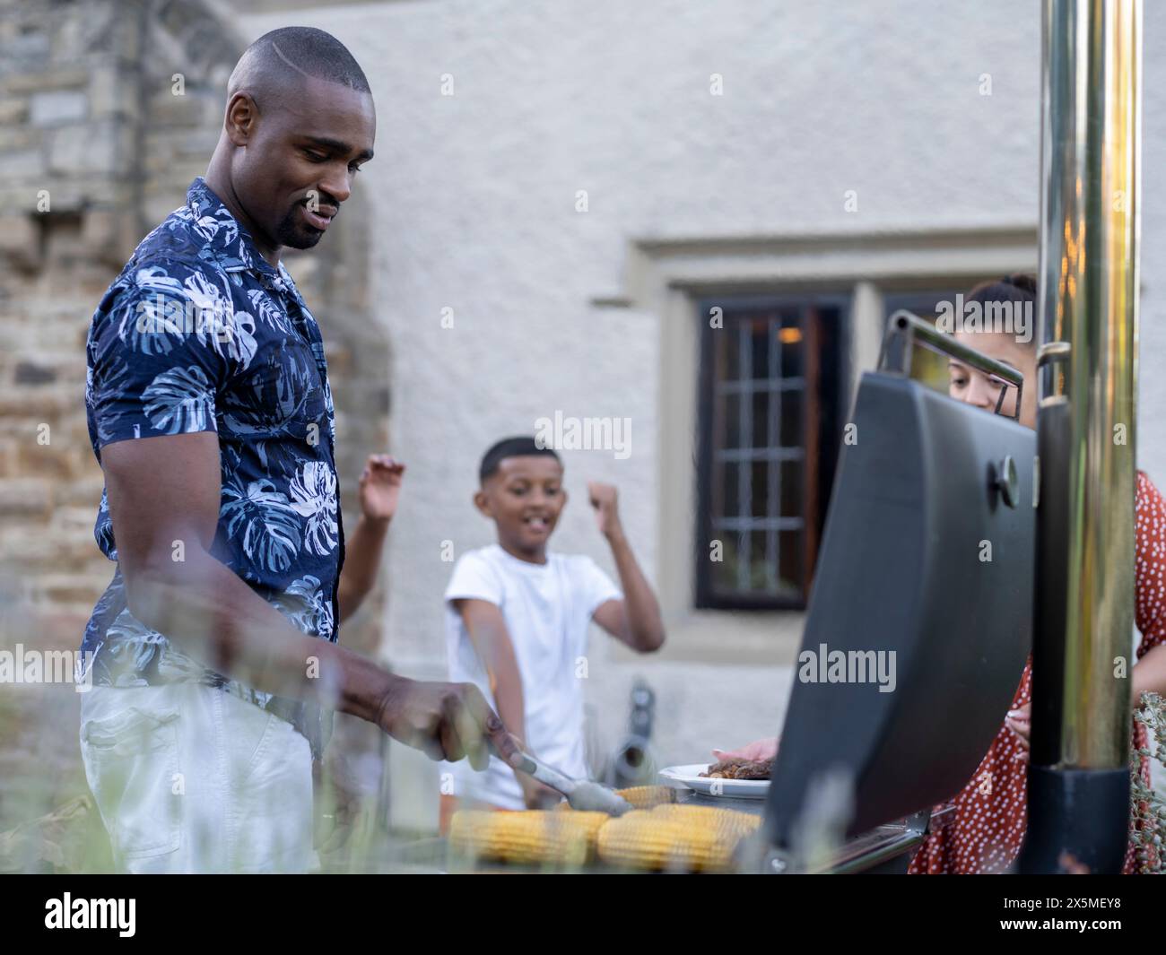 Famiglia con bambini (8-9, 10-11) con barbecue Foto Stock
